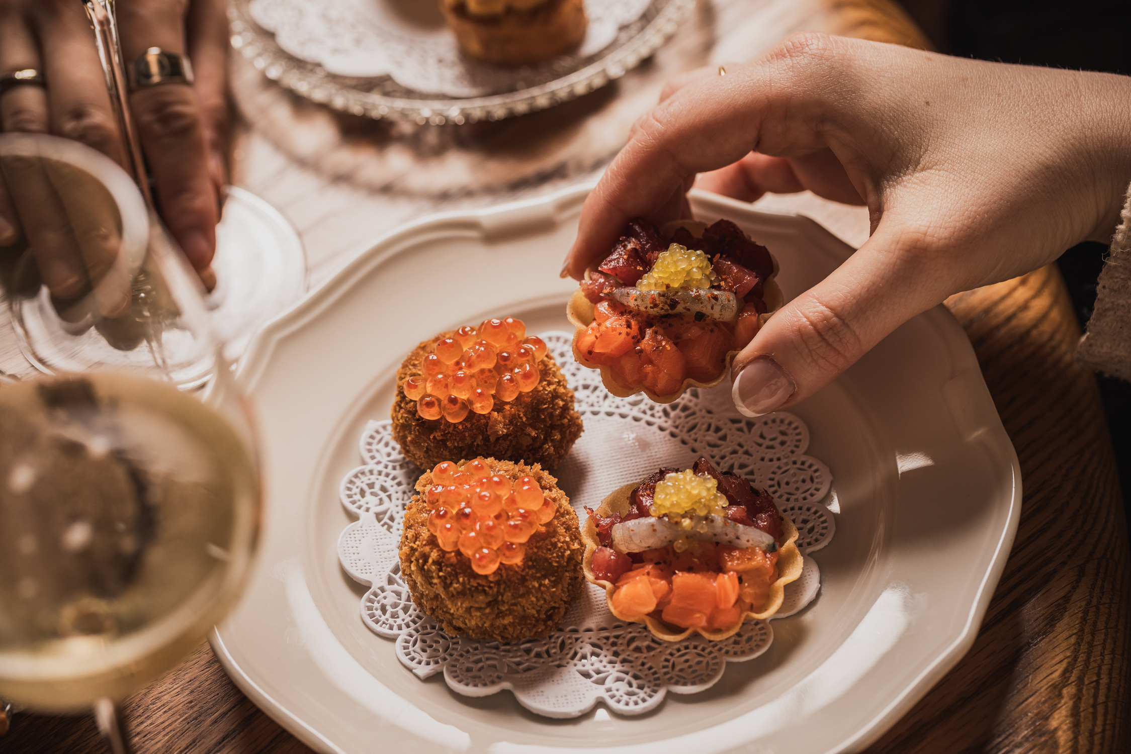 hands picking up seafood raw tart
