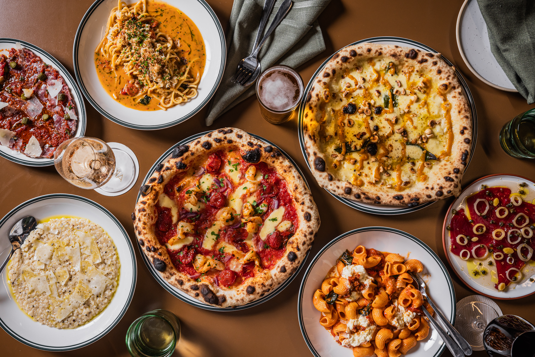 mixed pizzas and pastas on table for sharing