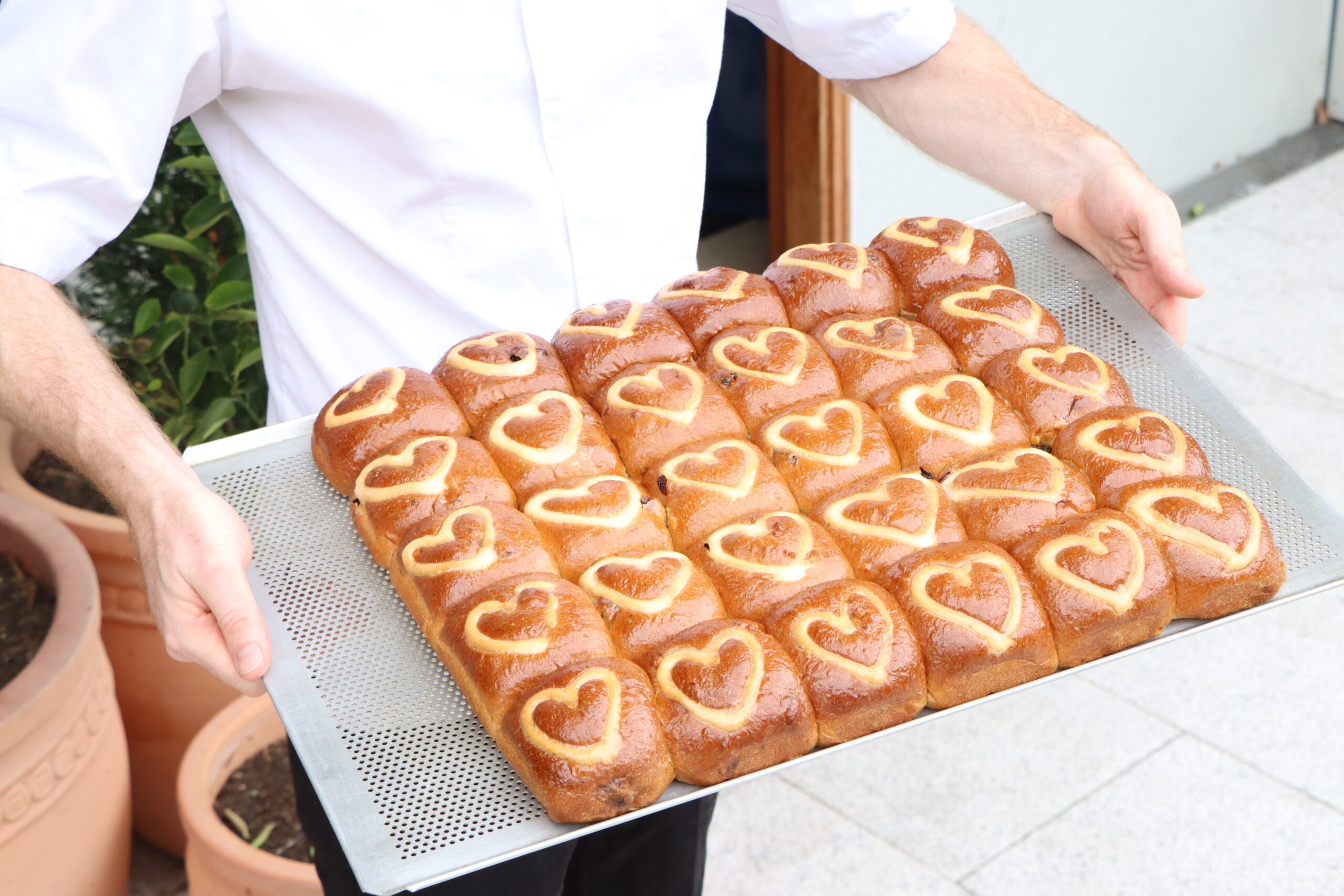 baker holding hot cross buns for easter